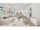 Bright, modern living room features an open floor plan, sleek white furniture, and stylish decor with hardwood floors at 9530 Coastline Way, Parrish, FL 34219