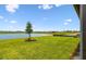 Large backyard with lush green grass and a tranquil pond view, perfect for outdoor activities and relaxation at 10317 Cross River Trl, Parrish, FL 34219