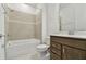 Well-lit bathroom features a shower-tub combo with modern tile and a stylish vanity with granite countertop at 10317 Cross River Trl, Parrish, FL 34219