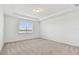 Bedroom with neutral carpet, tray ceiling, and a window offering a serene view at 10317 Cross River Trl, Parrish, FL 34219