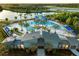 Aerial view of a clubhouse overlooking a resort-style community pool and lake at 10317 Cross River Trl, Parrish, FL 34219