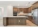 Modern kitchen with stainless steel appliances, a spacious island, and stylish wood cabinets at 10317 Cross River Trl, Parrish, FL 34219