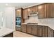 Well-equipped kitchen with stainless steel oven, range hood and appliances, quartz countertop and tiled backsplash at 10317 Cross River Trl, Parrish, FL 34219
