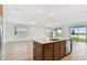 Open-concept kitchen island with stainless steel appliances, views of the living area and backyard lake at 10317 Cross River Trl, Parrish, FL 34219