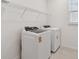 Bright laundry room features new white washer and dryer appliances with wire shelf for storage at 10317 Cross River Trl, Parrish, FL 34219