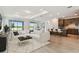 Bright living room featuring a large sectional sofa, open floorplan and scenic water views through sliding glass doors at 10317 Cross River Trl, Parrish, FL 34219
