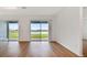 Bright living room featuring hardwood floors and sliding glass doors that open to a scenic waterfront view at 10317 Cross River Trl, Parrish, FL 34219