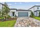 Charming single-story home featuring a gray garage door and meticulously landscaped front yard at 10414 Cross River Trl, Parrish, FL 34219