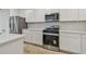 The kitchen boasts white cabinets, stainless steel appliances, and stylish hexagon backsplash at 10414 Cross River Trl, Parrish, FL 34219