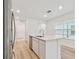 Kitchen island with sink, white cabinets, quartz countertop, and stainless steel dishwasher at 10414 Cross River Trl, Parrish, FL 34219