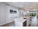 Modern kitchen with white cabinets, stainless steel appliances, quartz countertops, and a view to the outside at 10414 Cross River Trl, Parrish, FL 34219
