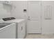 Functional laundry room with a washer, dryer, shelving, and easy outdoor access at 10414 Cross River Trl, Parrish, FL 34219