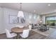 Living room with stylish furniture, a decorative rug, white walls and a view to a screened-in lanai at 10414 Cross River Trl, Parrish, FL 34219