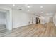 Open-concept living room with wood-look flooring offering a modern and spacious design at 10414 Cross River Trl, Parrish, FL 34219