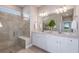 Elegant main bathroom with dual vanities, granite countertops, a walk-in shower, and neutral tile at 10414 Cross River Trl, Parrish, FL 34219