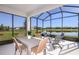 Screened patio with dining and lounge furniture overlooking a serene lake and landscaped backyard at 10414 Cross River Trl, Parrish, FL 34219