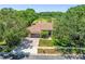Aerial view of a home with a tile roof, three-car garage, and golf course views at 1084 Berkshire Ln, Tarpon Springs, FL 34688