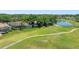 Aerial view of backyard featuring pool and golf course in a lush neighborhood at 1084 Berkshire Ln, Tarpon Springs, FL 34688