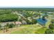 Aerial view of home, ponds, golf course and surrounding lush neighborhood at 1084 Berkshire Ln, Tarpon Springs, FL 34688