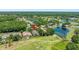Aerial view of home, ponds, golf course and surrounding lush neighborhood at 1084 Berkshire Ln, Tarpon Springs, FL 34688