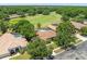 Expansive aerial view of the property showcasing tile roof, screened lanai and surrounding lush landscaping at 1084 Berkshire Ln, Tarpon Springs, FL 34688