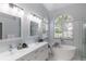Bathroom featuring a soaker tub, glass shower, and double vanity at 1084 Berkshire Ln, Tarpon Springs, FL 34688