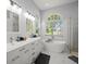Elegant bathroom featuring a double sink vanity, a freestanding soaking tub, and an arched window with natural light at 1084 Berkshire Ln, Tarpon Springs, FL 34688