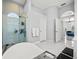 Modern bathroom featuring a glass-enclosed shower, a freestanding soaking tub, and an arched doorway leading to the bedroom at 1084 Berkshire Ln, Tarpon Springs, FL 34688