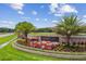 Landscaped community entrance sign with palm trees and colorful flowerbeds at 1084 Berkshire Ln, Tarpon Springs, FL 34688
