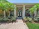 Inviting front entryway featuring double doors, decorative columns, and lush landscaping at 1084 Berkshire Ln, Tarpon Springs, FL 34688