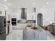 Spacious kitchen features white cabinets, stainless appliances, large marble island, and tile backsplash at 1084 Berkshire Ln, Tarpon Springs, FL 34688