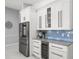Elegant kitchen with stainless steel fridge, wine cooler, and classic white cabinetry at 1084 Berkshire Ln, Tarpon Springs, FL 34688