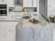 Detailed view of the kitchen island, featuring marble countertop, sink, and seating at 1084 Berkshire Ln, Tarpon Springs, FL 34688