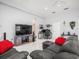 Comfortable living room with black leather sofas and gaming setup, bathed in natural light from the nearby windows at 1084 Berkshire Ln, Tarpon Springs, FL 34688