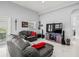 Spacious living room with modern decor, including a large TV and comfortable leather sofas with red accent pillows at 1084 Berkshire Ln, Tarpon Springs, FL 34688