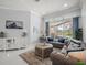 Bright and airy living room with comfortable sofas, stylish decor, and access to the lanai at 1084 Berkshire Ln, Tarpon Springs, FL 34688