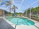 Inviting screened-in pool with a spa and lounge chairs, surrounded by lush landscaping at 1084 Berkshire Ln, Tarpon Springs, FL 34688