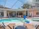 Beautiful screened-in pool area with hot tub, lounge seating, and an outdoor kitchen at 1084 Berkshire Ln, Tarpon Springs, FL 34688