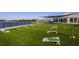 Lawn area with multiple cornhole game sets with lake view in the background at 11448 Shoreline Trl, Parrish, FL 34219