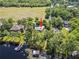 Aerial view highlighting the home’s position near the water, dock, and neighboring properties with a red arrow at 18906 Crescent Rd, Odessa, FL 33556