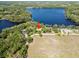 Expansive aerial view of property nestled near a large lake, showcasing the setting and highlighted with red arrow at 18906 Crescent Rd, Odessa, FL 33556