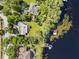 Bird's-eye view showing the home's layout, surrounding greenery, boat dock, and lake access for waterfront living at 18906 Crescent Rd, Odessa, FL 33556