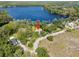 Aerial shot showcasing the home nestled among trees, with stunning lake views, highlighted with a red arrow at 18906 Crescent Rd, Odessa, FL 33556