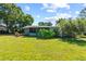 Backyard featuring mature landscaping, lush grass, and screened-in porch at 18906 Crescent Rd, Odessa, FL 33556
