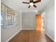 Bright bedroom with wood-look floors, large window, ceiling fan and neutral paint at 18906 Crescent Rd, Odessa, FL 33556