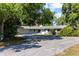 Inviting single-story home with an attached garage, well-maintained lawn, and shady trees at 18906 Crescent Rd, Odessa, FL 33556