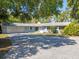 Charming single-story home featuring a blue exterior, mature trees, and an expansive driveway at 18906 Crescent Rd, Odessa, FL 33556