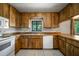 Kitchen boasts wood cabinets, white appliances, tile flooring and natural light at 18906 Crescent Rd, Odessa, FL 33556