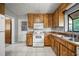 Kitchen with white appliances, wood cabinets, and tile floors at 18906 Crescent Rd, Odessa, FL 33556