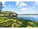 Scenic lakeside view featuring a weathered boathouse extending into the serene water, surrounded by lush greenery at 18906 Crescent Rd, Odessa, FL 33556